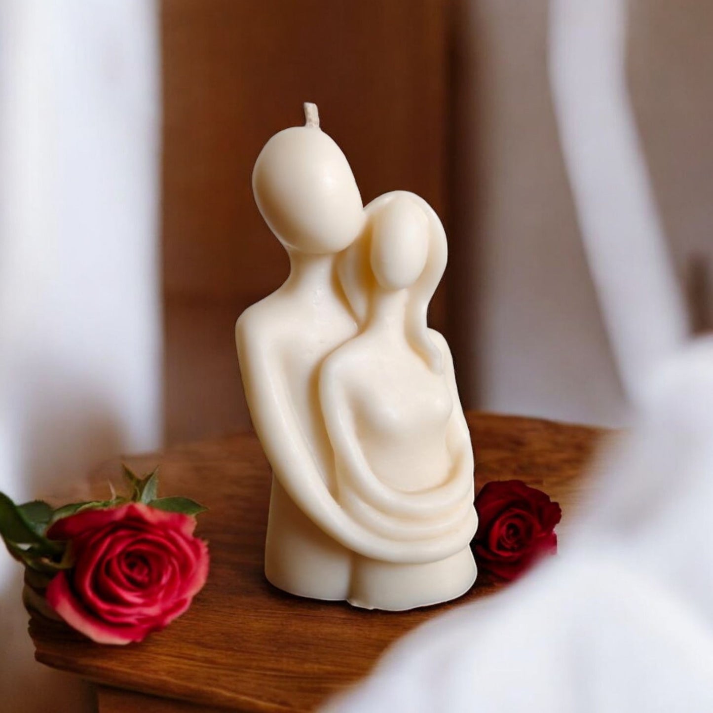 Couple hugging candle placed on a wooden table