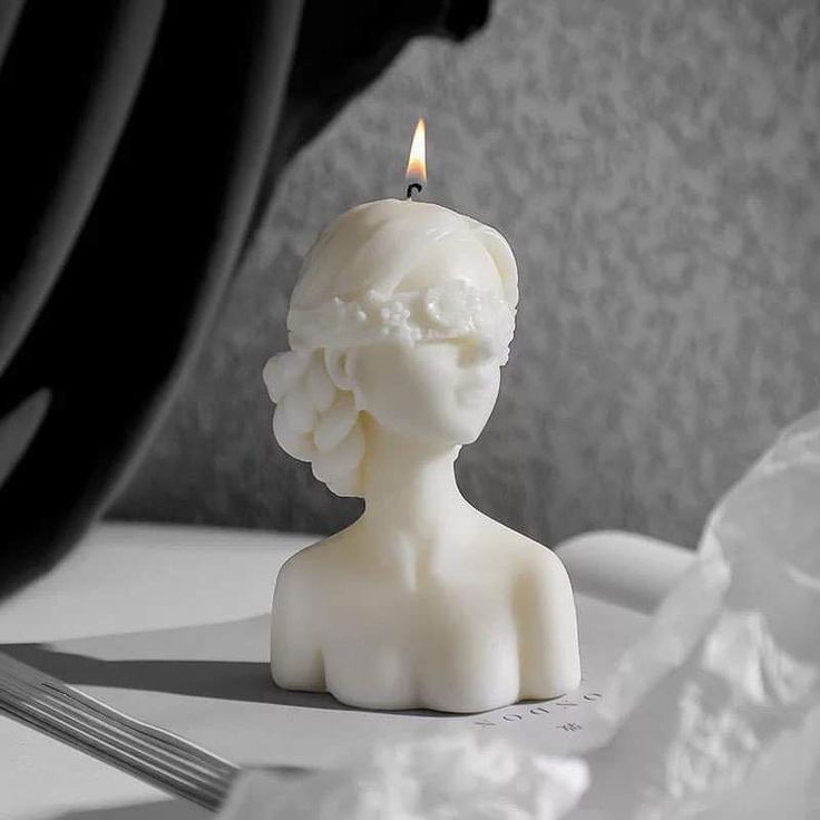 Blindfolded lady candle placed on a book and has been lit