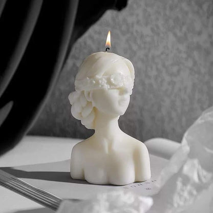 Blindfolded lady candle placed on a book and has been lit