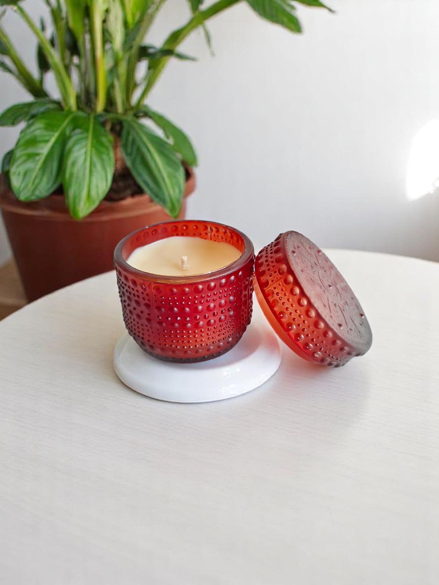 Brown dotted jar candle on a white coaster