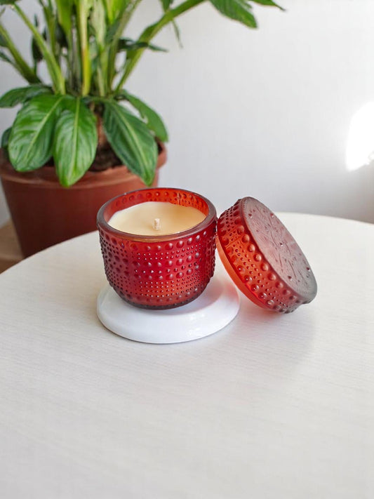 Brown dotted jar candle on a white coaster