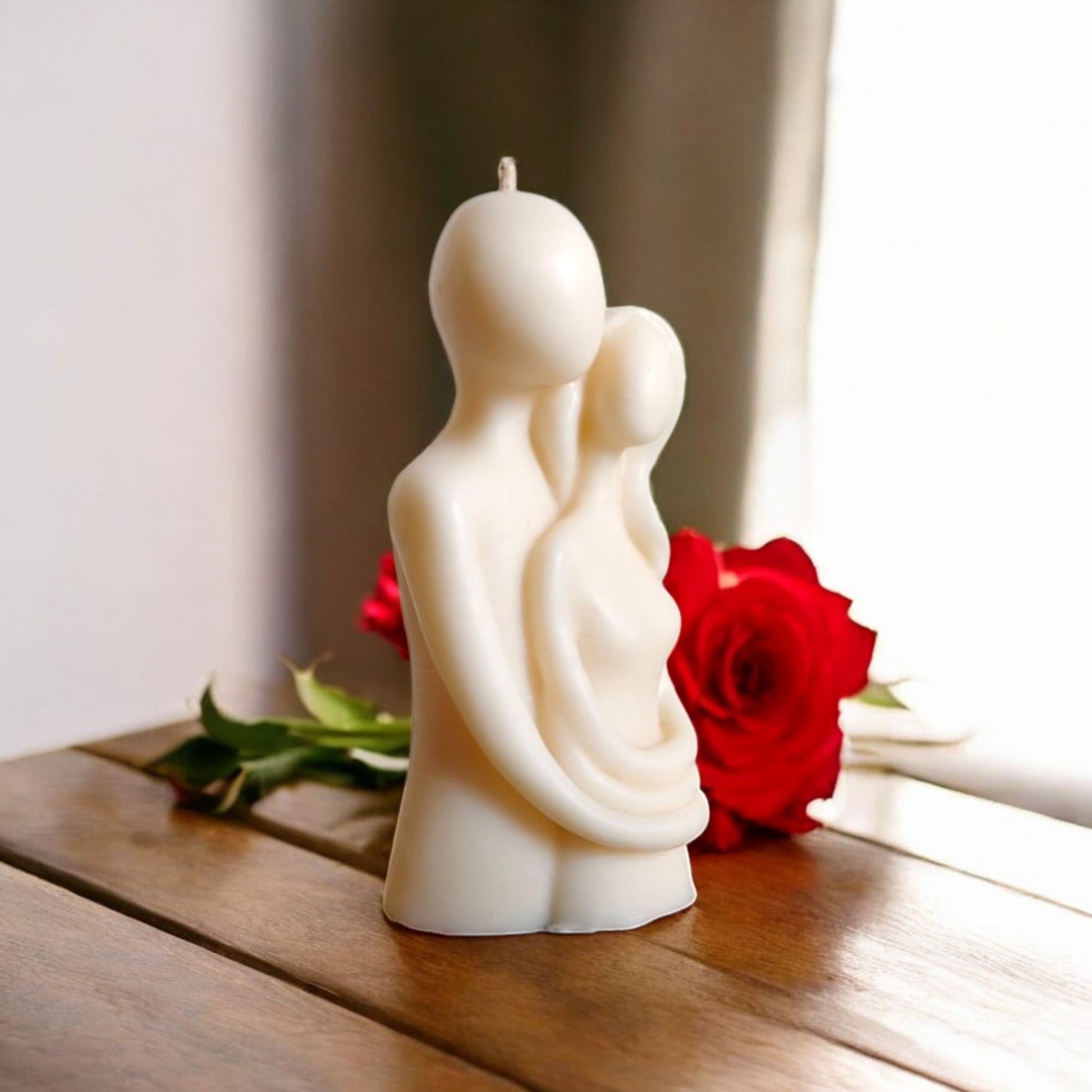 Couple hugging candle placed on a wooden table