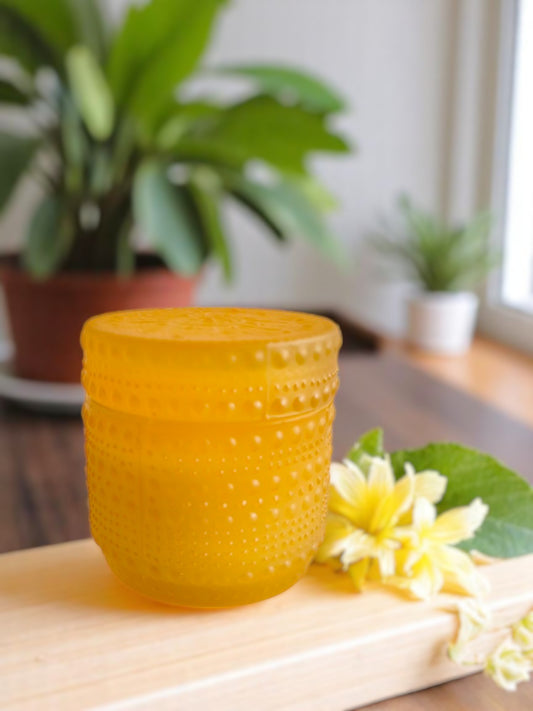 Yellow dotted jar candle on a wooden base