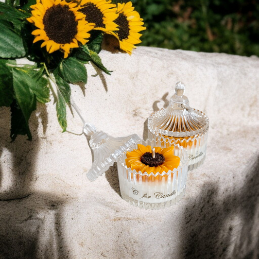 Sunflower candle in a crystal glass jar on a rock